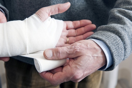 Doctor, bandaging a strained wrist of a patient with a swathing bandの写真素材