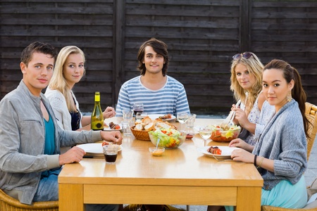 Portrait of young friends enjoying meal at outdoor party
