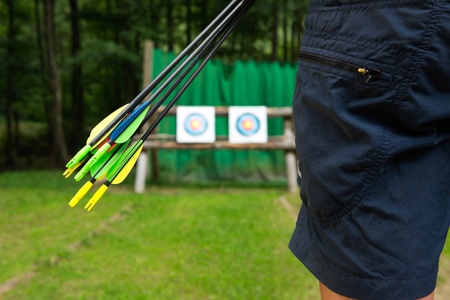 Close up of an archer with arrows standing in fronts of the target