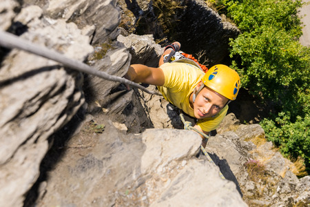 High angle portrait of young man climbing rockの写真素材