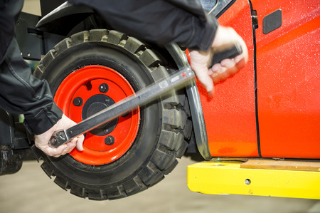 Maintenace on a forklift, a worker is changing the tyres  の写真素材