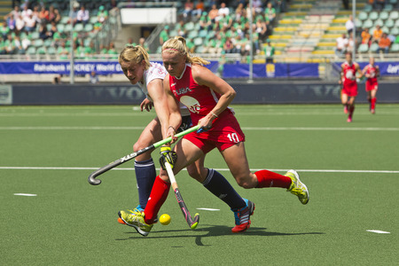 THE HAGUE, NETHERLANDS - JUNE 1: GBR field hockey player Zoe Shipperley Reaches for the ball across USA Jill Witmer and so during the Hockey World Cup 2014 in the Kyocera Stadium in the preliminary match between England and USA (1-2) on June 1, 2014 in Thのeditorial素材