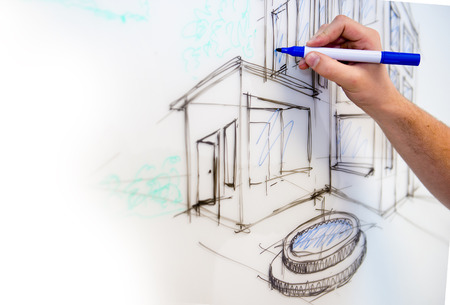 Man's hand creating a free drawing of a mansion in perspective on a whiteboard as rough sketchの写真素材