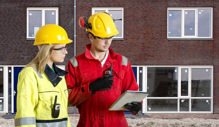 Foreman and real estate development manager going over an electronic checklist during the delivery...