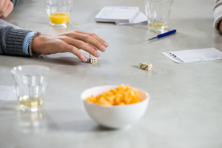 Cropped image of man playing dice game at tableの写真素材