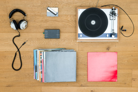 Directly above shot of turntable with records and headphones on wooden tableの写真素材