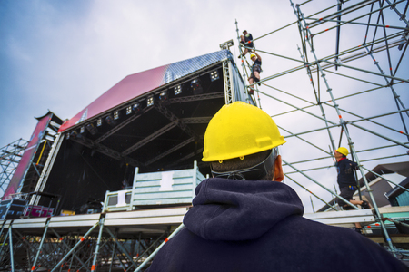 team building up the music stage for a festival, with personal protective equipmentの写真素材