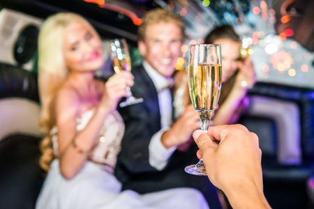 Hand Toasting Champagne Flute With Friends In Limousineの写真素材