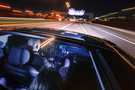driving at night on a highway with people in the car, seen through the glass roofの写真素材