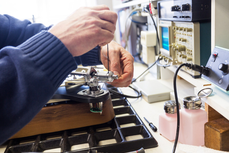 mounting and adjusting the counterweight to repair the arm of a turntableの写真素材