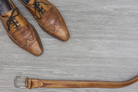 top view from matching men shoes and belt, on a wooden floor, top view