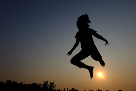a shadow of the girl jumping in the sunset