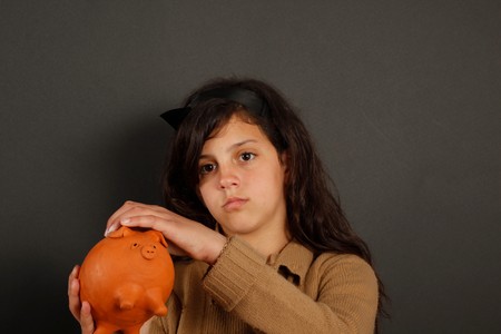 A young girl put save money in his piggy bankの写真素材