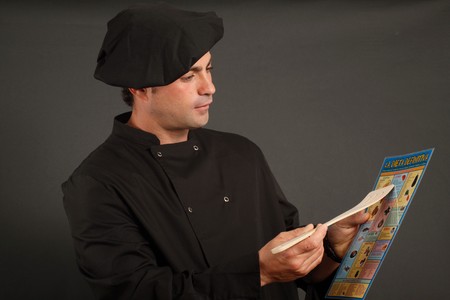 Spanish cook wearing black hat showing a diet boardの写真素材