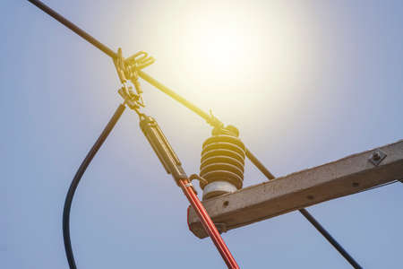 The power lineman uses insutated tool to open the connection of the transformer from the high...