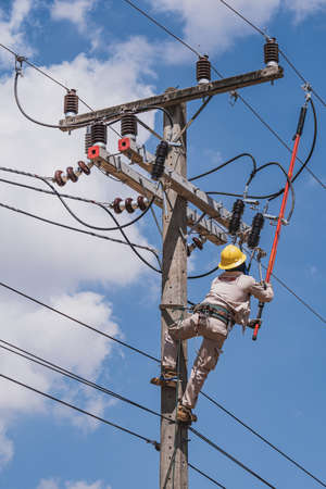 The power lineman use clamp stick (insulated tool) to closing a transformer on energized...