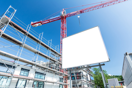 Blank billboard at front of scaffolding and craneの写真素材