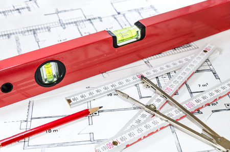 Spirit level with measurement tools on building planの写真素材