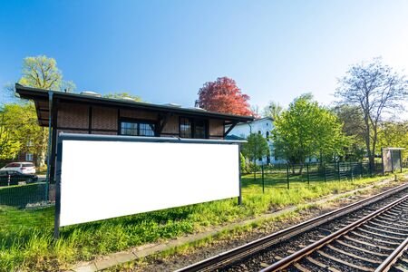 Blank widescreen poster on house wall next to the rails at the stationの写真素材