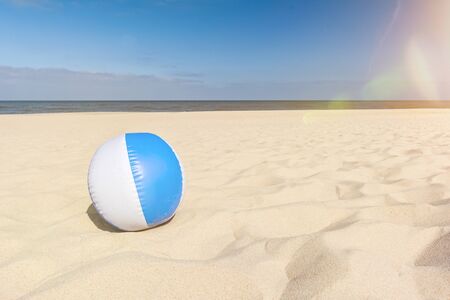 Beach ball on a beautiful beach in summer with scenic lens flareの写真素材