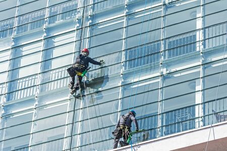 Window cleaner on glass facade of a skyscraper