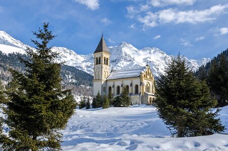 Romantic historic chapel in beautiful mountain landscape in winterの写真素材