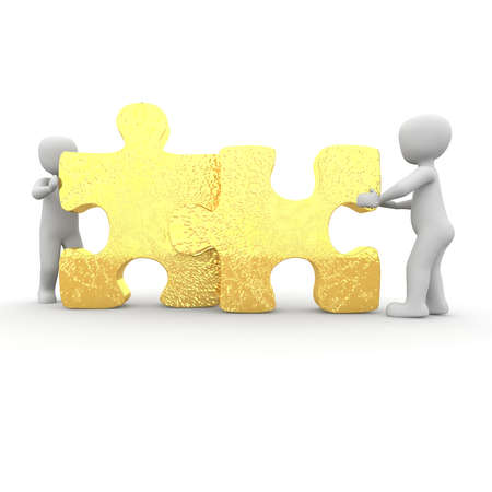 The two characters move two large puzzle pieces together.の写真素材