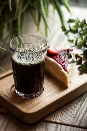 Desserts for coffee, a glass with a drink and cheesecake, berries, upright.