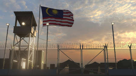 Waving flag of Malaysia above military base in the eveningの写真素材