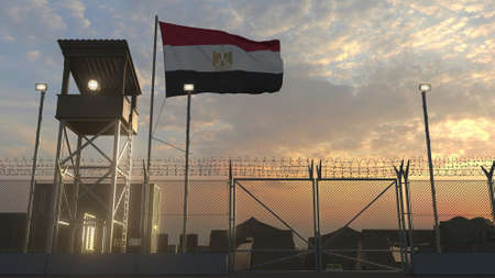 National flag of Egypt above military base at sunsetの写真素材
