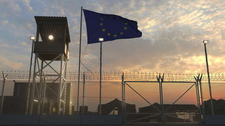 Waving flag of the European Union above military base in the eveningの写真素材