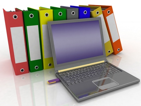 Colorful folders next to a modern laptopの写真素材