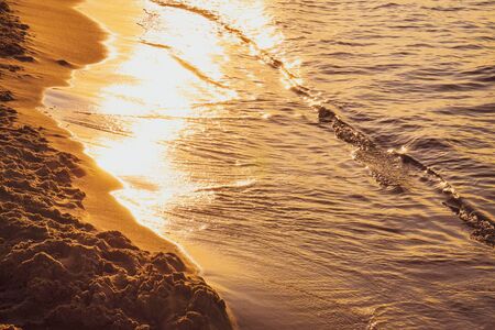 Sunset - sun reflecting in waves, shoreの写真素材