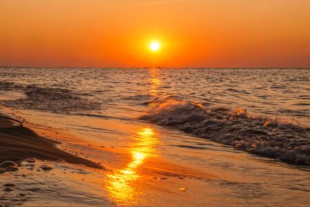 Sunset - sun reflecting in sea/ ocean, shoreの写真素材