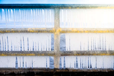 Icicles hanging on a barrier - frost, winter conceptの写真素材