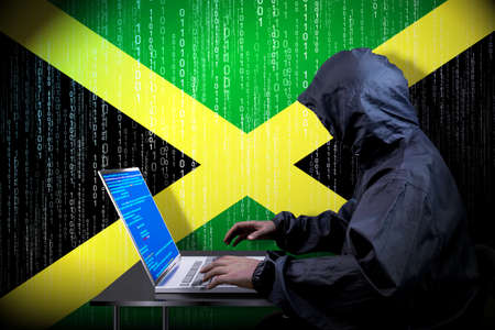 Anonymous hooded hacker, flag of Jamaica, binary code - cyber attack concept