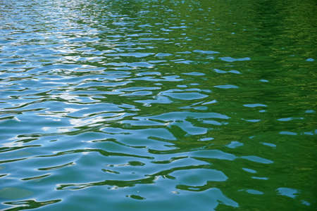 Ripples on water surface - sky reflectionの写真素材