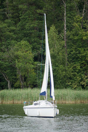 Sailboat swimming on a lake - front view