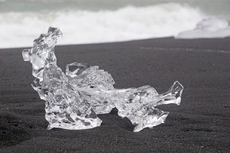 Block of ice on a black, volcanic shore - Diamond Beach, Jokulsarlon, Iceland.