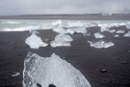 Blocks of ice laying on black volcanic sand - Diamond Beach, Jokulsarlon, Icelandの写真素材