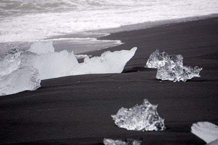 Blocks of ice laying on black volcanic sand - Diamond Beach, Jokulsarlon, Icelandの写真素材