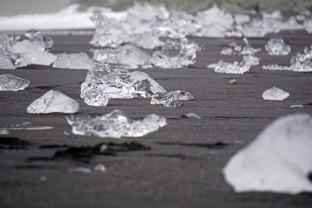 Blocks of ice laying on black volcanic sand - Diamond Beach, Jokulsarlon, Icelandの写真素材