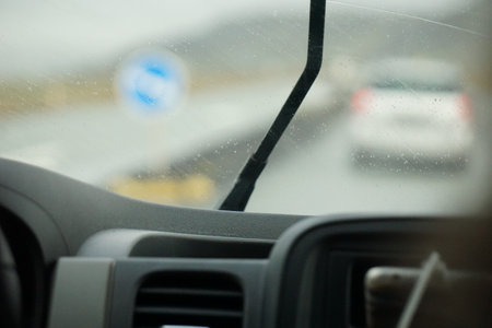 Driving a car in the rain with activated windshield wipersの写真素材