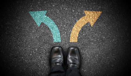 Black business shoes and two colorful chalky arrows on asphalt - choice conceptの写真素材