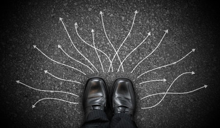 Black business shoes and many winding chalky arrows on asphalt - decision conceptの写真素材