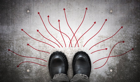Heavy black leather boots and many winding arrows on ground - decision concept