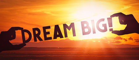 Dream big - human hands holding black silhouette words