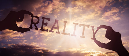 Reality - human hands holding black silhouette wordの写真素材