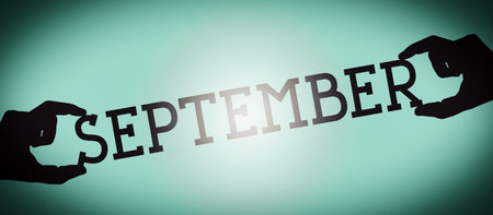 September - human hands holding black silhouette word, gradient background