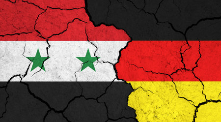 Flags of Syria and Germany on cracked surface - politics, relationship concept